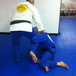 Victor grips Robert's lapel and kicks his right foot out.