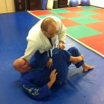 Victor steps his left leg back and uses a combination of knee pressure and a crossface while maintaining control of Robert's knee.